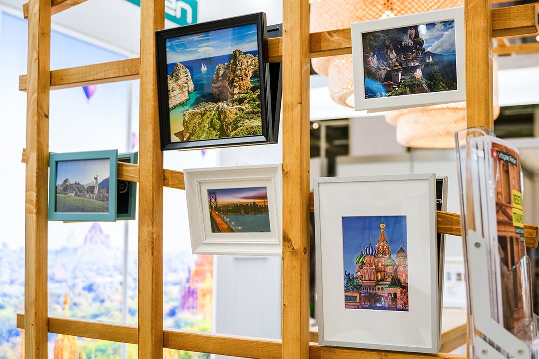 Nahaufnahme von aufgehängten Bildern im modularen Messestand von Vögele Reisen an der Ferienmesse in Bern.