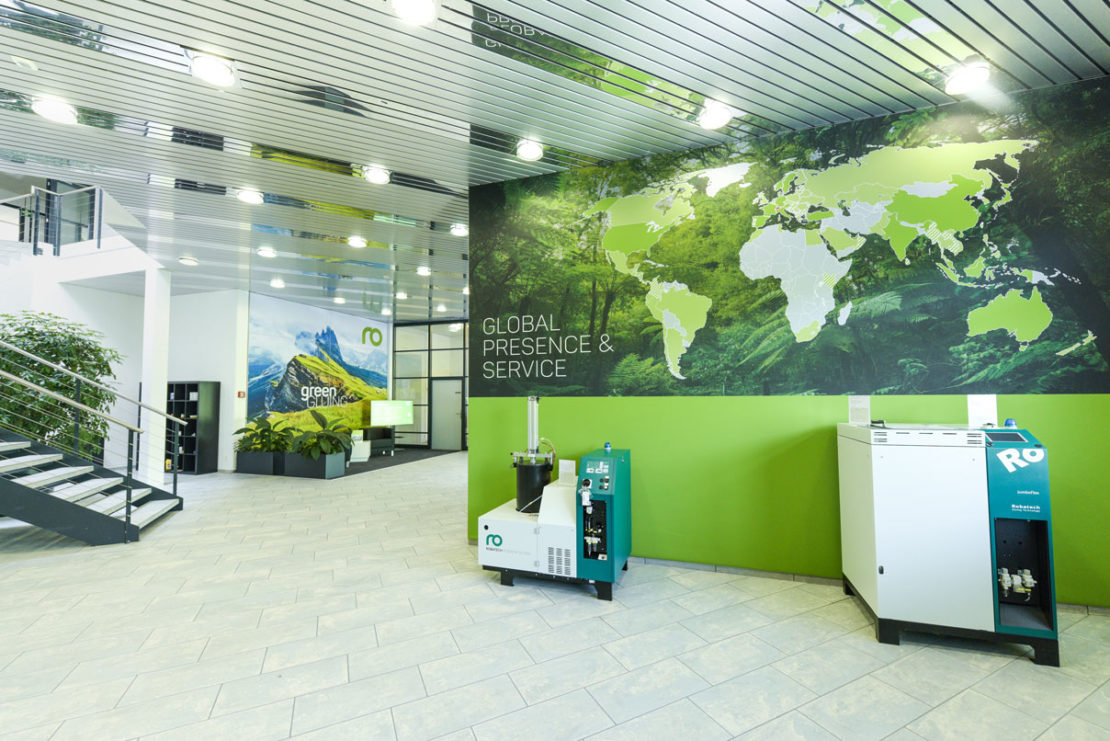 Showroom von Robatec mit zwei Maschinen und Grafiken von unserem Projektleiter in grün.